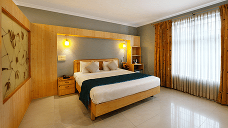 A spacious Suite with a king size bed and large windows - Cross Roads Inn, Bengaluru