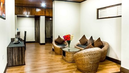 An image of the ecotel suite with bamboo sofa set and center table, a work desk in a room which is brightly lit Ecotel Tin Tin, Bijanbari