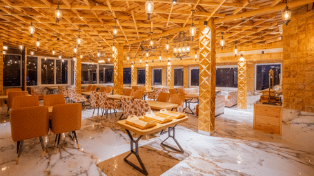 The main dining room showing a buffet setup and wide windows overlooking the hills - Golden Oak By The Lake Hill, Khurpatal