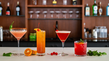 Four vibrant looking drinks with decoratives placed on a counter-top at Mandala Norling Lords Prime in Kathmandu.