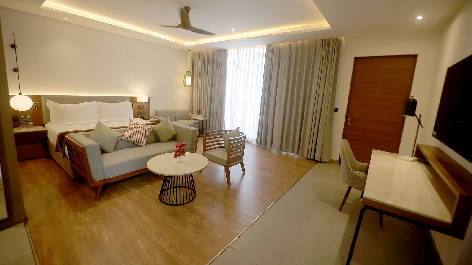 Elegant room with modern lighting, twin sofas, a coffee table, and work desk at Wyndham Garden.