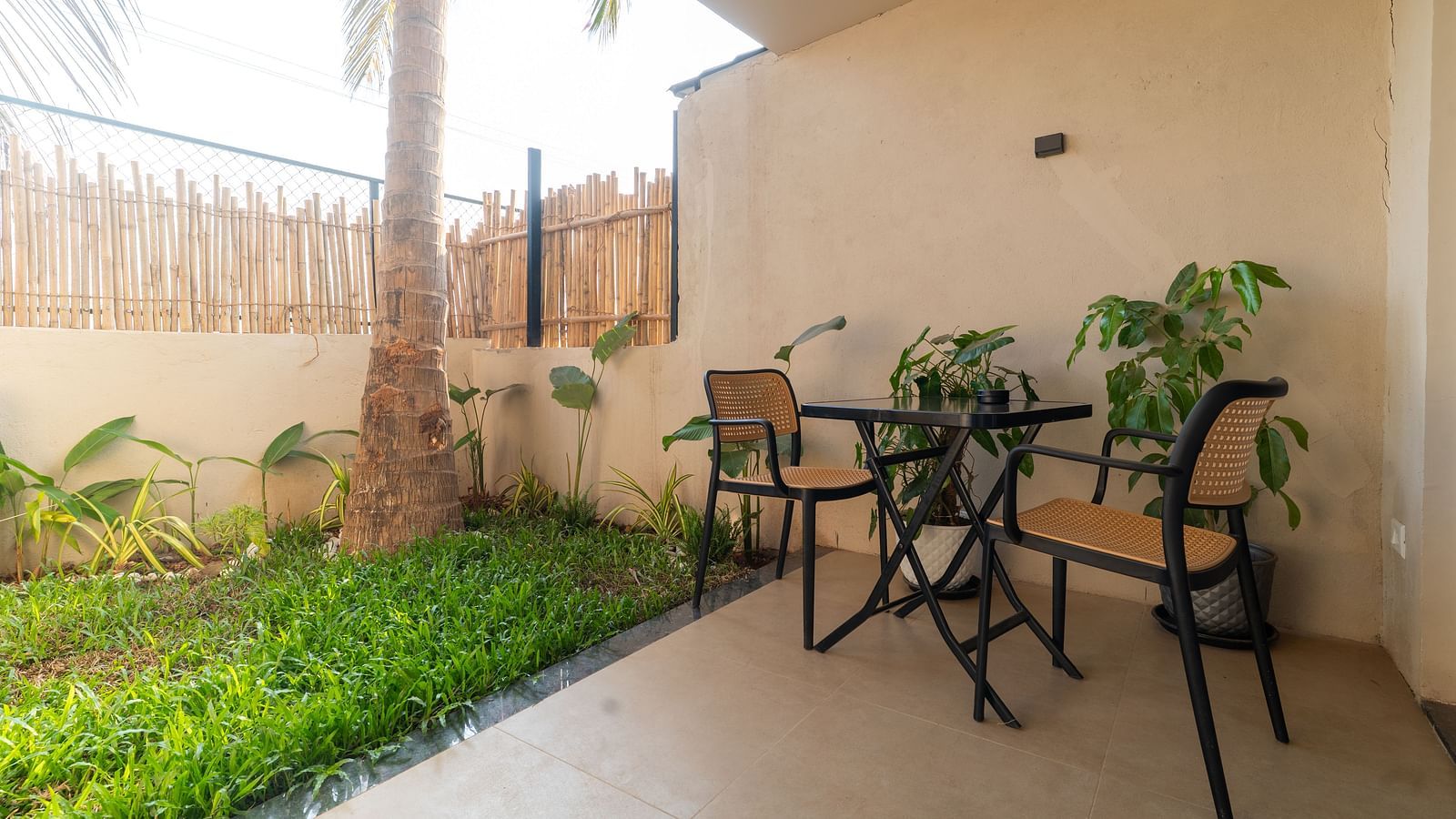 Charming private garden patio with table and chairs surrounded by greenery at Kssemya.