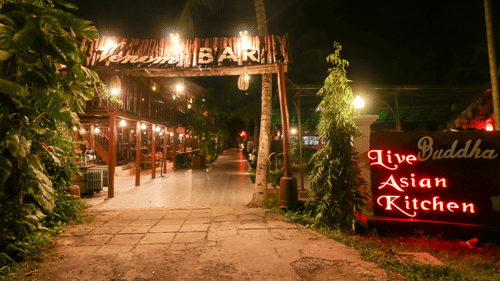 Facade view of the entrance to Venom Bar at Symphony Palms Beach Resort And Spa at night.