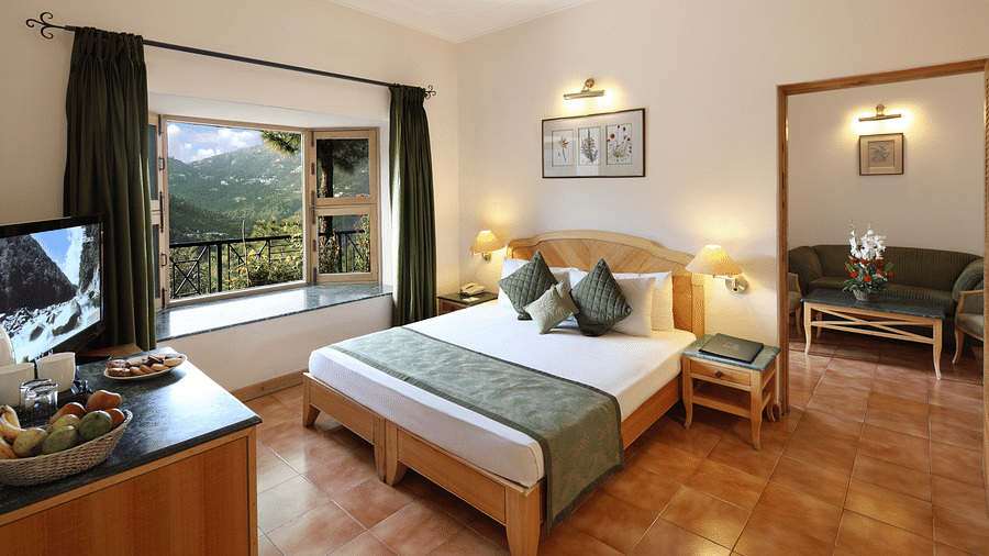 a bedroom with a large double bed with side drawers and large windows  - Baikunth Resort, Kasauli