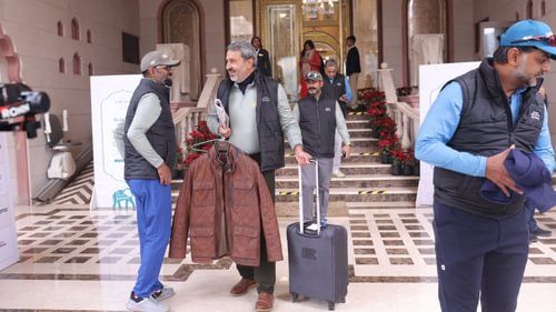 A group of people heading towards the golf course from Heritage Village Resorts & Spa with luggage and suitcases to attend game day 