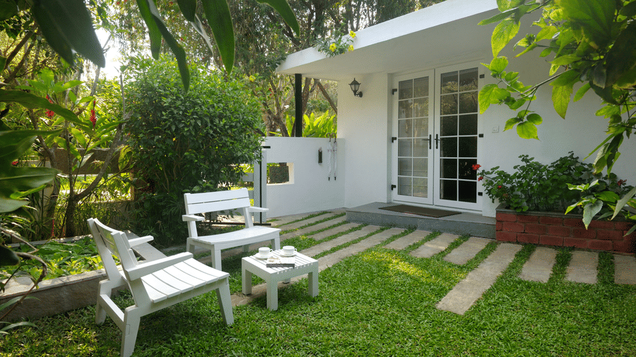 White outdoor seating arrangement at the garden-courtyard at Amanvana Spa Resort, Coorg