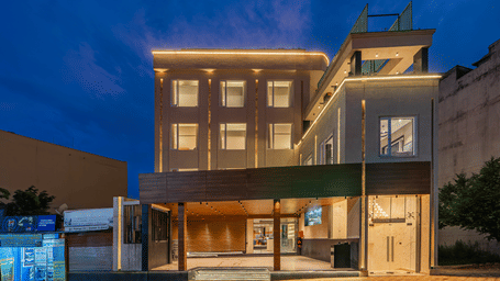 The exterior facade of Perfectstayz Premium Mahadev Regency, Katra glows with exterior lighting at dusk.