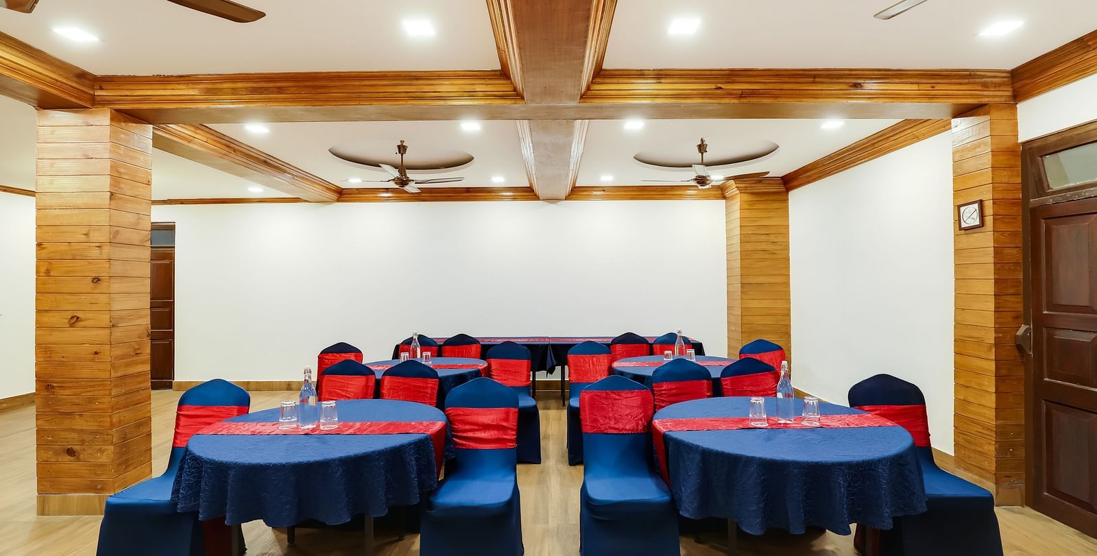 A close up shot of the banquet hall that features a seating arrangement with round blue tables and blue chairs.