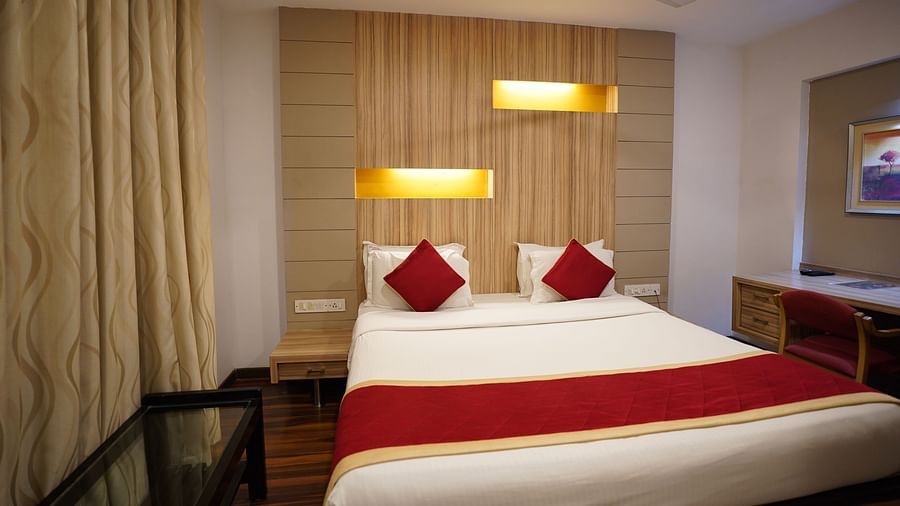 an image of a front view of deluxe bedroom with a wooden headboard at City Centre Residency