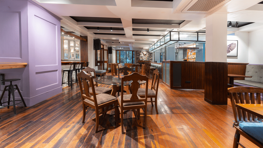 An elegant dining space featuring purple wall panels, wooden tables, and matching chairs - Johnson Lodge & Spa, Manali