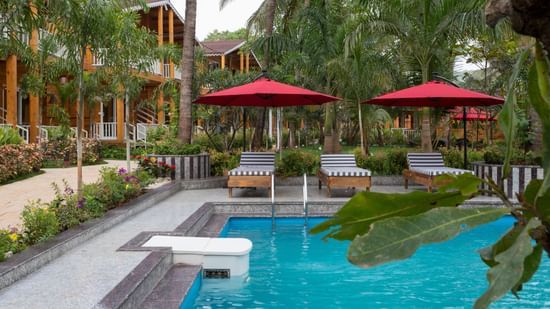 Overview of the pool area with canopies and lounger chairs in the background - Aralea Beach Resort by Stone Wood, Morjim