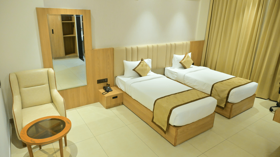 Bedroom of Bhavanis Vista By Icon featuring twin beds, a headboard, an armchair, and a mirror.