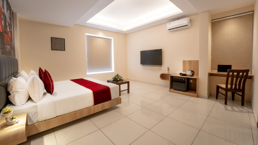 Spacious deluxe room with modern interiors, comfortable bed and seating area at Rivido - Manyata