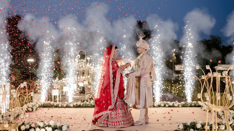Bride and groom making a grand entrance with fireworks during a night wedding at Umaid Palace.