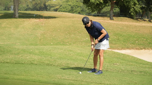 Golfer focusing on his stance while preparing for a shot at the golf course.
