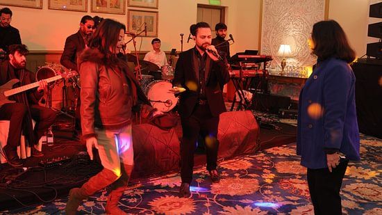 An image of a band performing where two people are singing and behind them there are musicians with guitars, drums, and other instruments at an event at Heritage Village Resorts & Spa