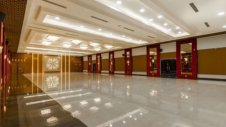 An angular shot of a long, empty hallway with a highly polished floor reflecting the ceiling and walls - Bamboo Saa Mulberry Resort, Pushkar
