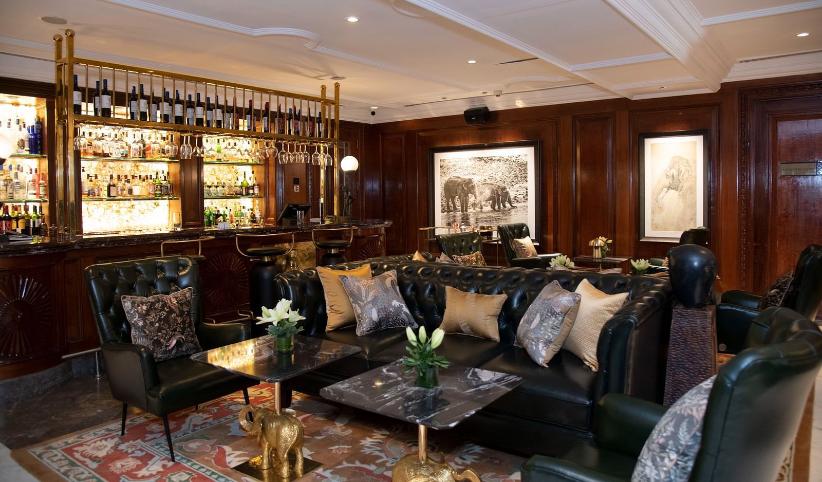 image of the elephant bar with elegant black leather couches at The Claridges New Delhi