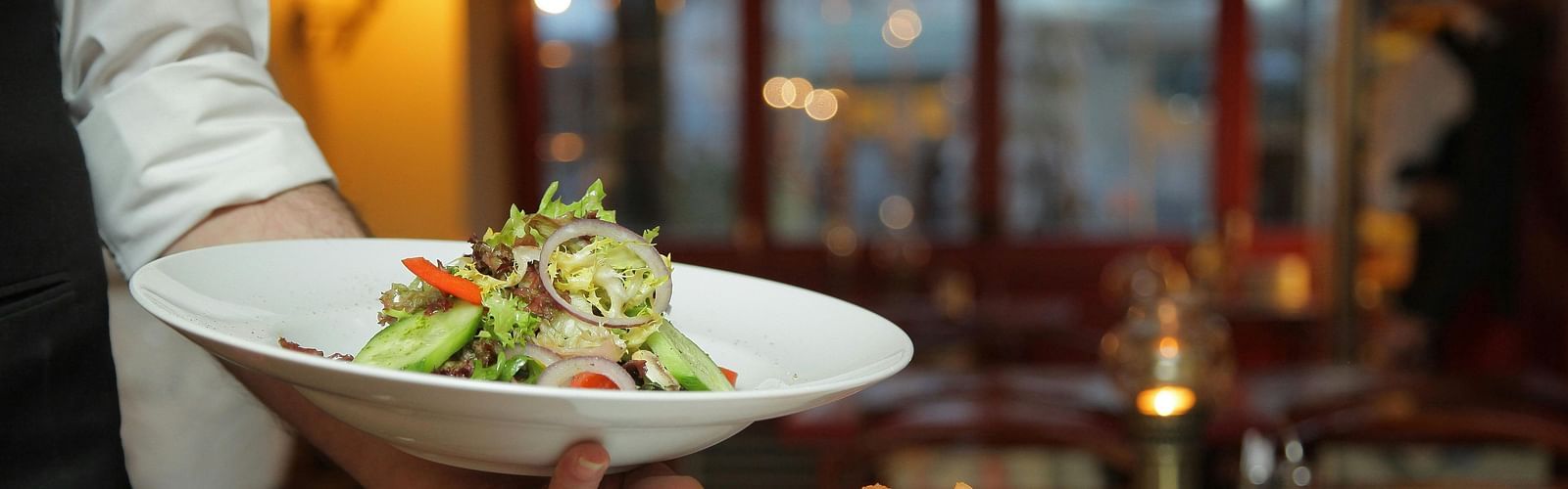 A waiter brings aesthetically arranged food to the table