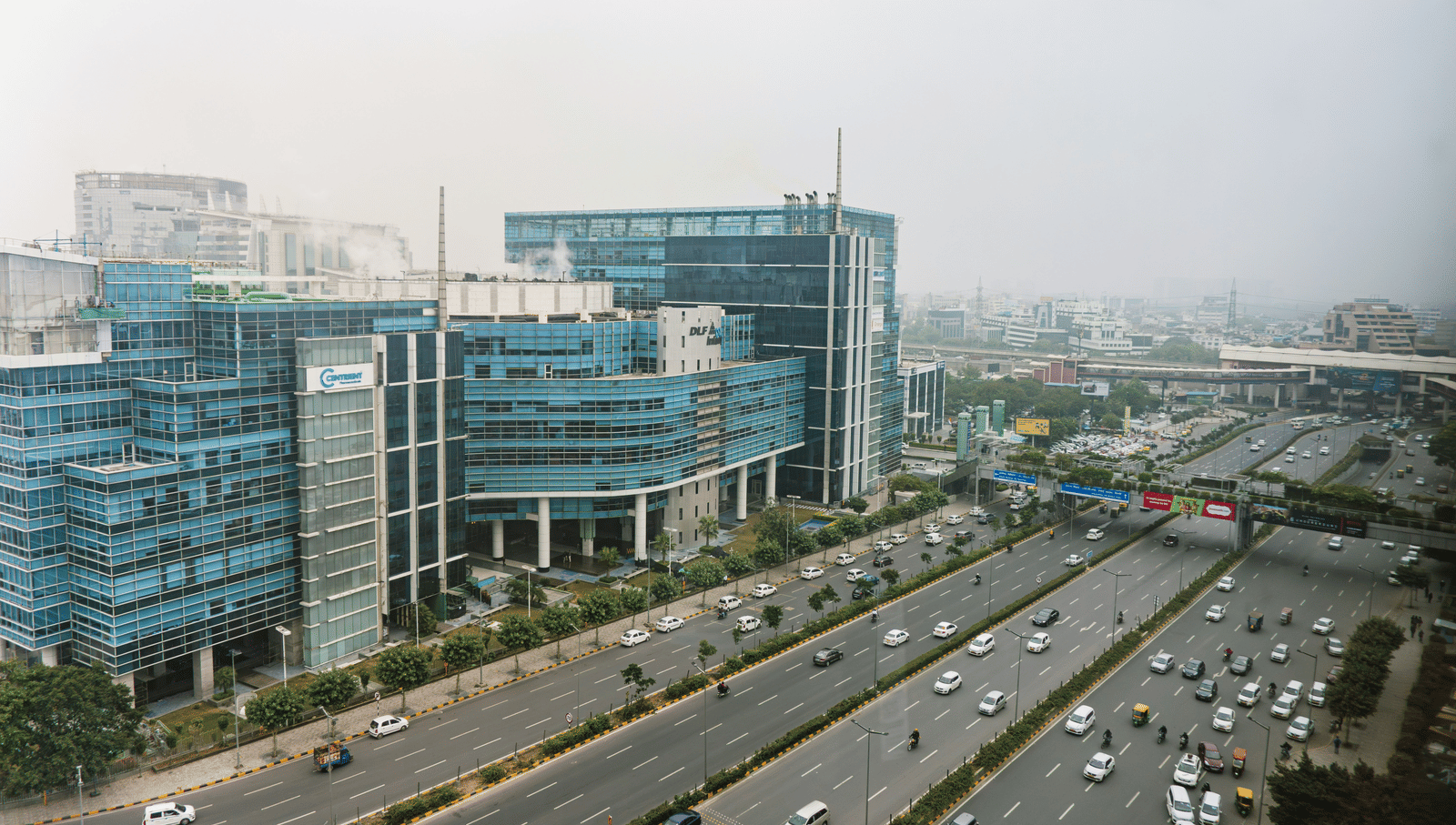 A panoramic view of a modern business district with multi-story buildings and a busy road