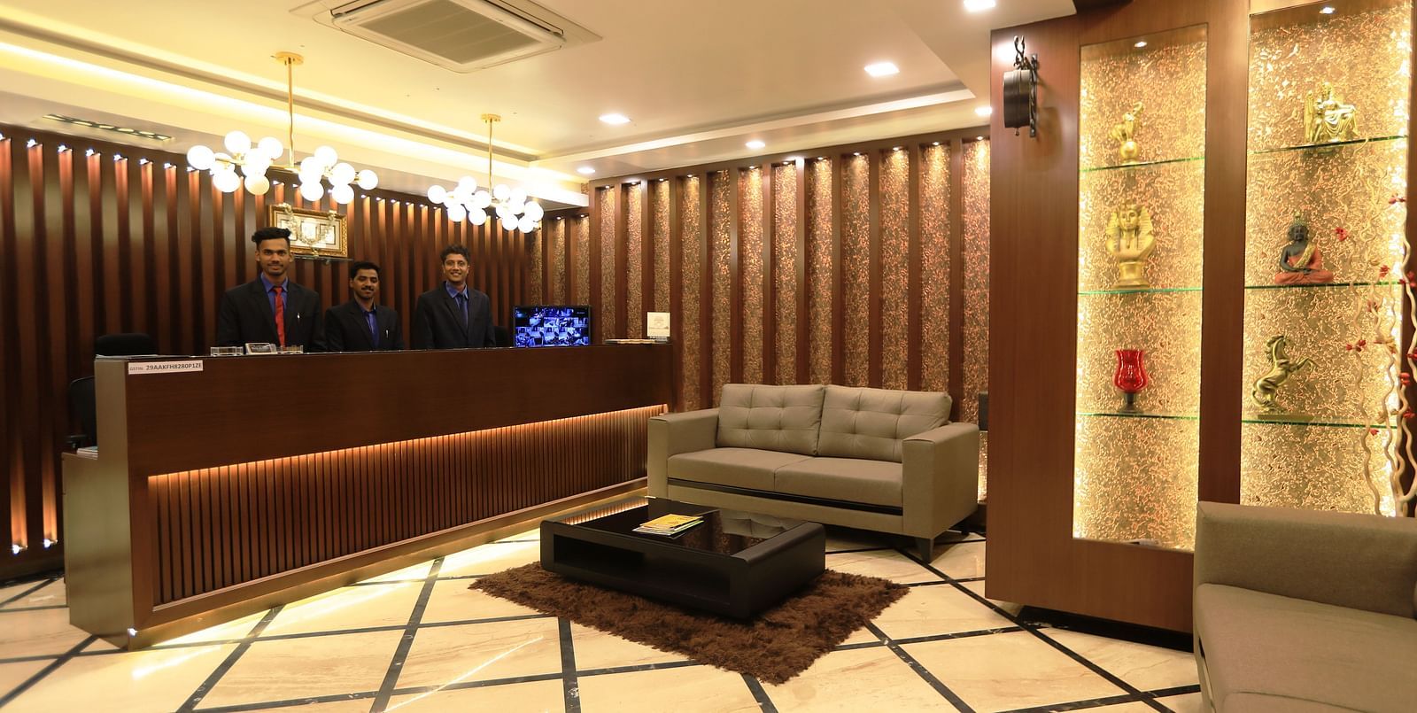 Image of a reception area with sofas and a table in the middle at Hotel Altitude, Madikeri.