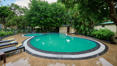 view of the pool and sun loungers at ABN Sarovar Portico, Jim Corbett