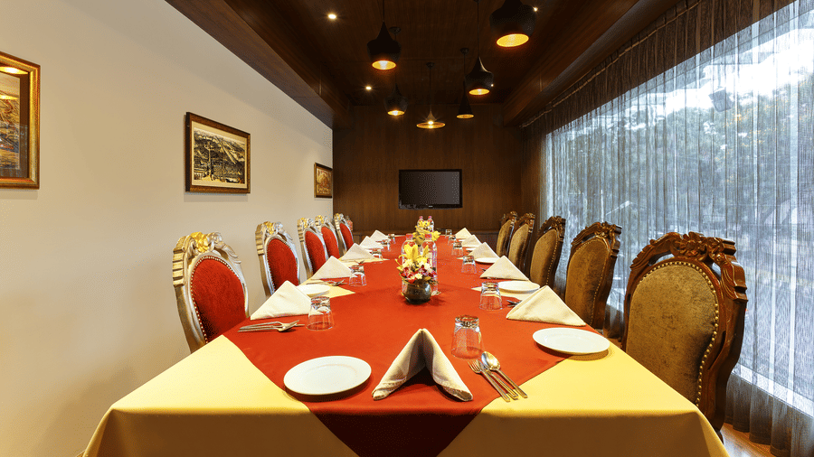 A dining table with plates, towels, cutlery, surrounded by several chairs - The Wild Fork