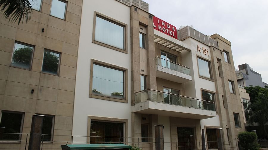 A facade image of Inde Hotels Vista Voods GUrgaon featuring a  triple storey building with huge windows and a board where the hotel name is mentioned
