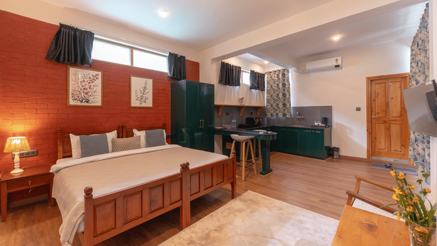 Full view of a studio suite including the bed, seating area, and open-plan kitchenette - Johnson Lodge & Spa, Manali