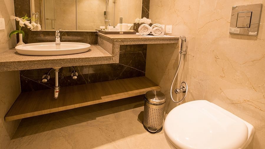Bathroom with bright lighting and a large mirror set horizontally above the washbasin.