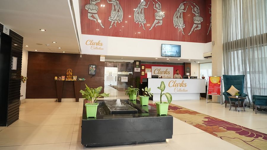 A reception area adorned with plants and a water fountain at Clarks Collection, Bhavnagar