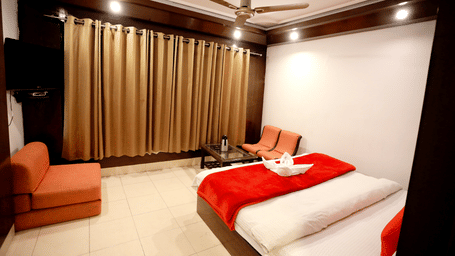 Image of a room with a bed and a seating area on the side at Amara Hill Queen, Mussoorie.