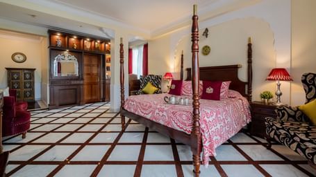  Guest bedroom with pink bedding, lampshade, and black-and-white tiled flooring at Dera Rawatsar, Jaipur.