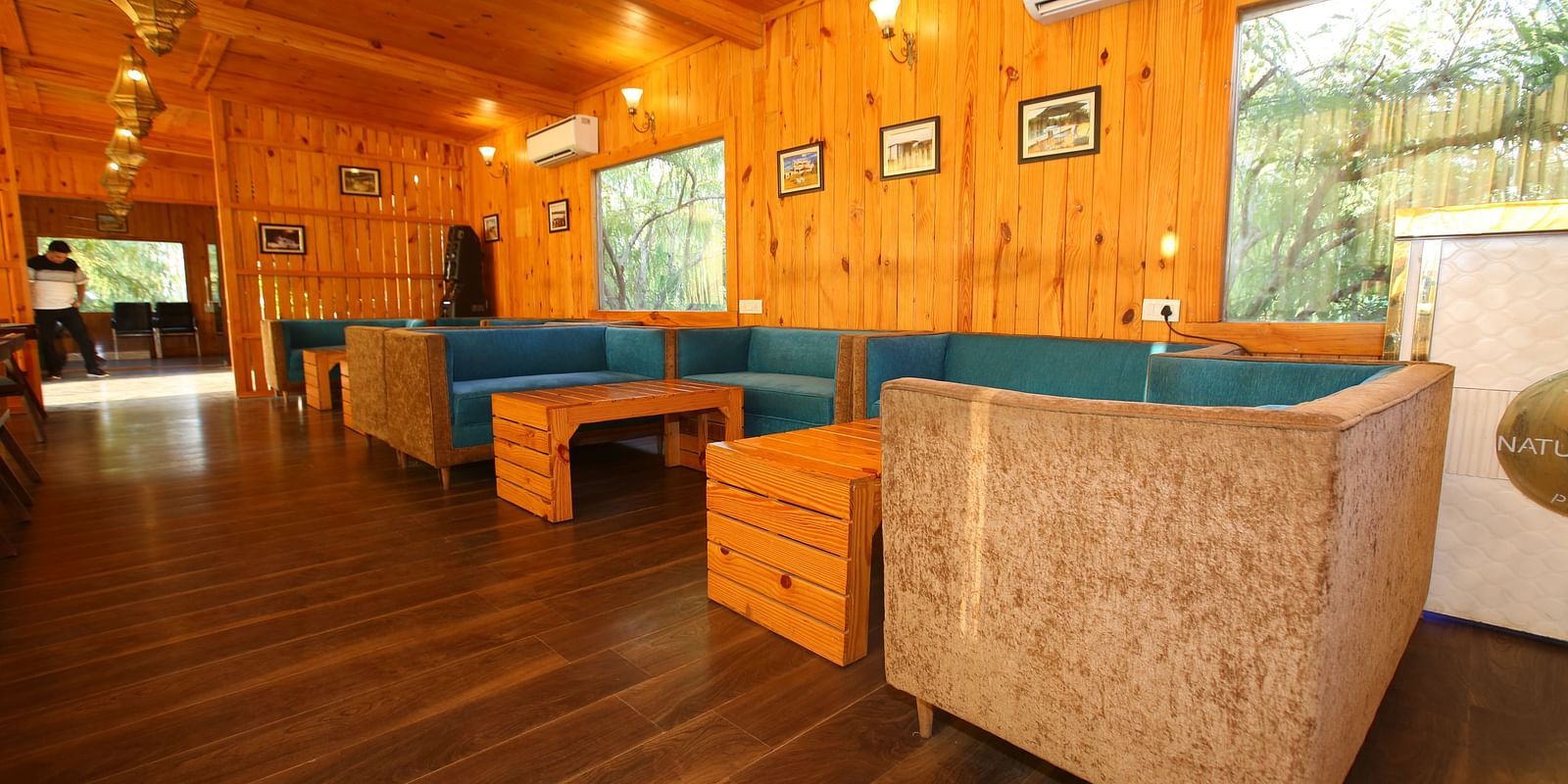 Dining area featuring a large, cozy sofa with a table in front at Aanandam Resort & Spa