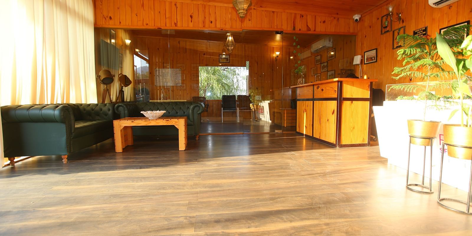 Reception area at Aanandam Resort & Spa featuring a large cozy sofa in the corner and a help desk on the opposite side