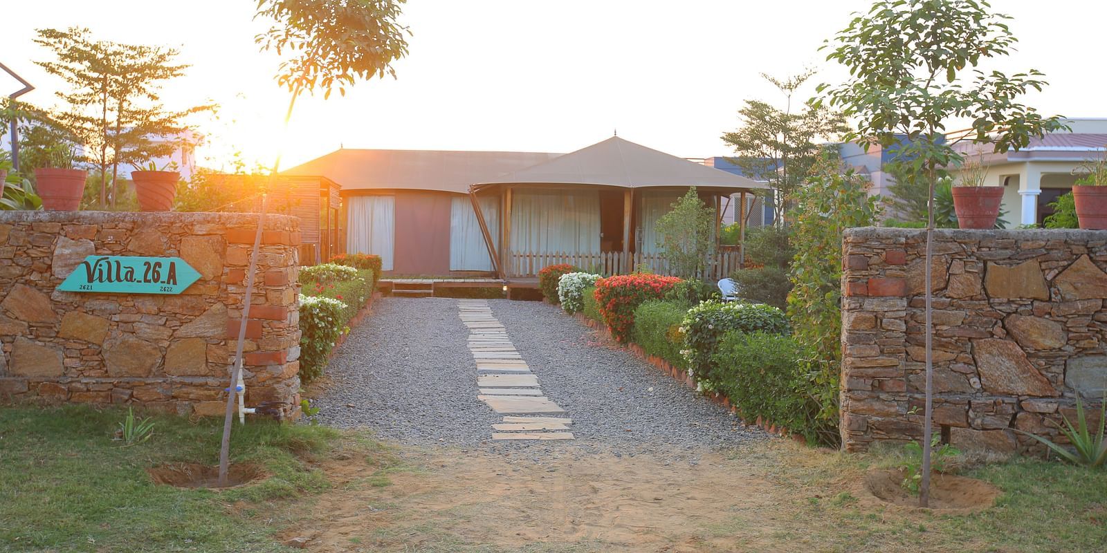 Front view of the Luxury Wooden Tent, with vibrant plants lining the pathway at Aanandam Resort & Spa