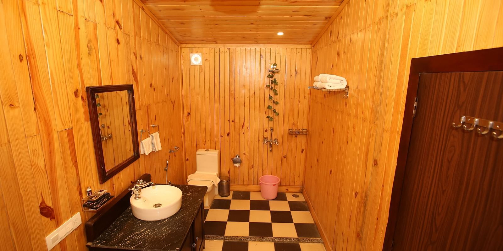 Kashmir Cottage Villa's Pool Room featuring a spacious washroom with wooden-style flooring, a modern sink, and a wall-mounted mirror at Aanandam Resort & Spa