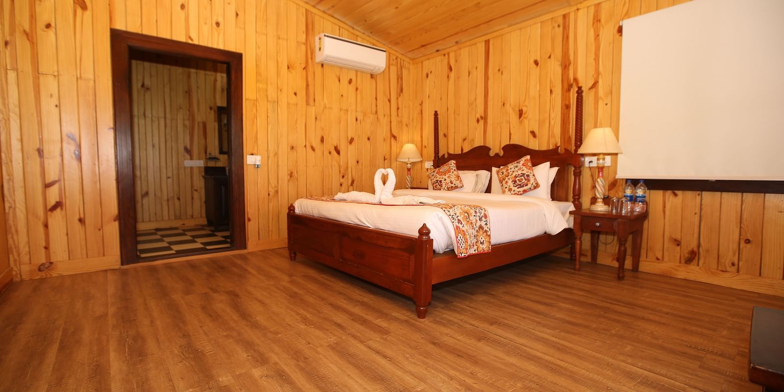 Spacious Kashmir Cottage Villa's Pool room with a king-sized bed, wooden flooring at Aanandam Resort & Spa