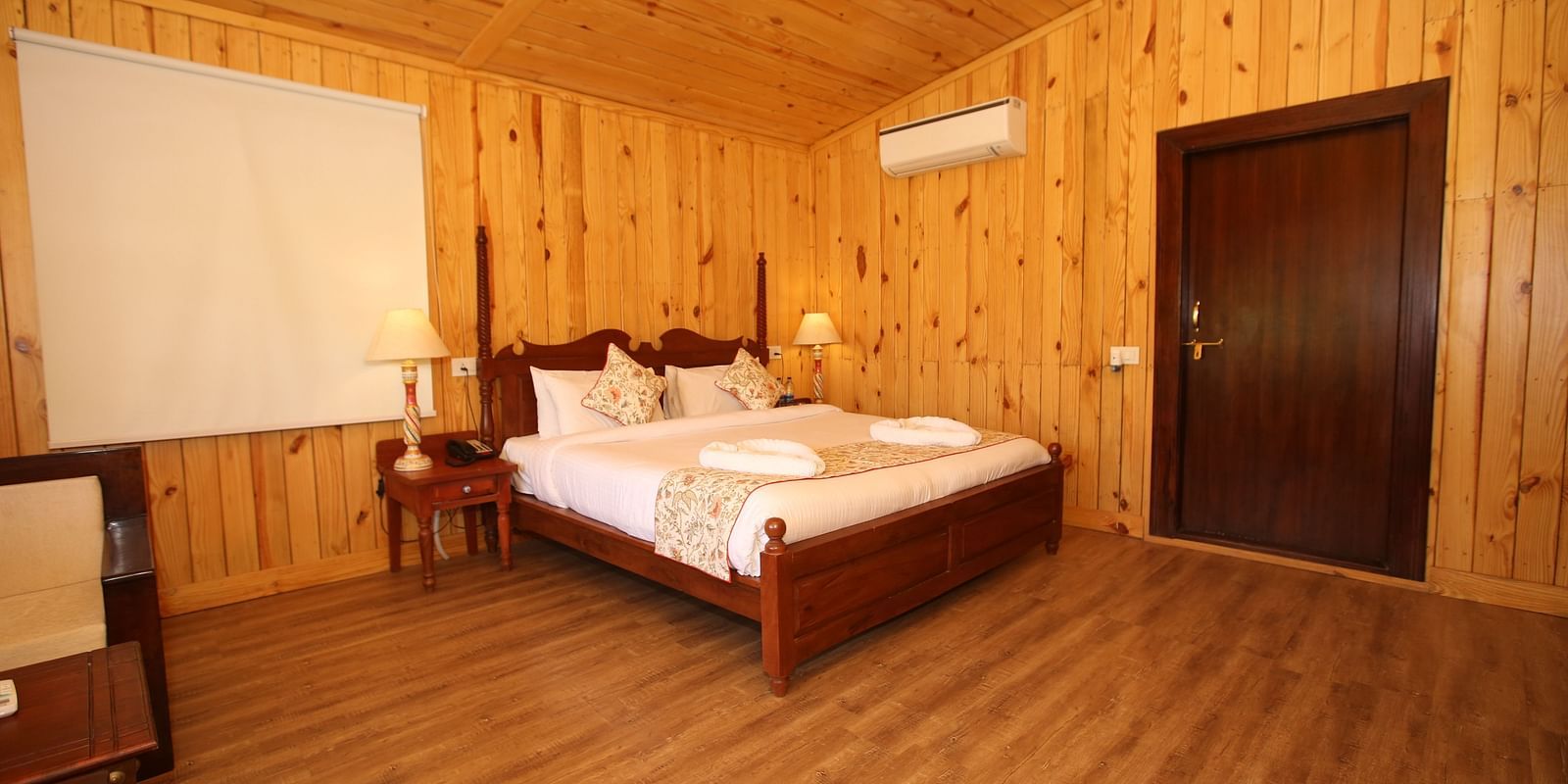 Kashmir Cottage Villa's Pool spacious room, featuring a king-sized bed and elegant wooden flooring at Aanandam Resort & Spa