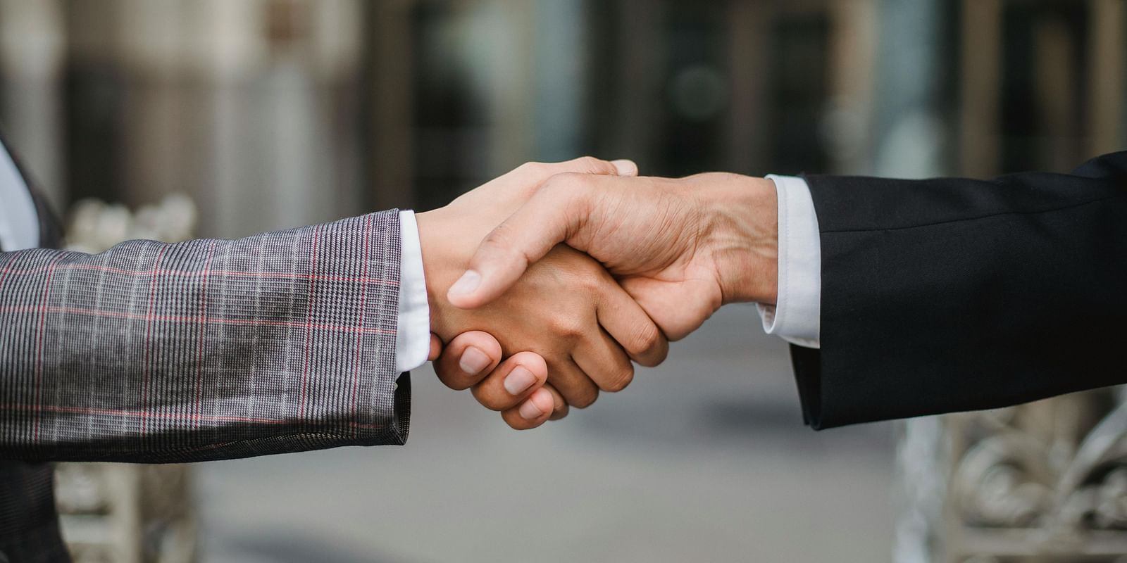 A close-up shot of two individuals in business attire shaking hands.