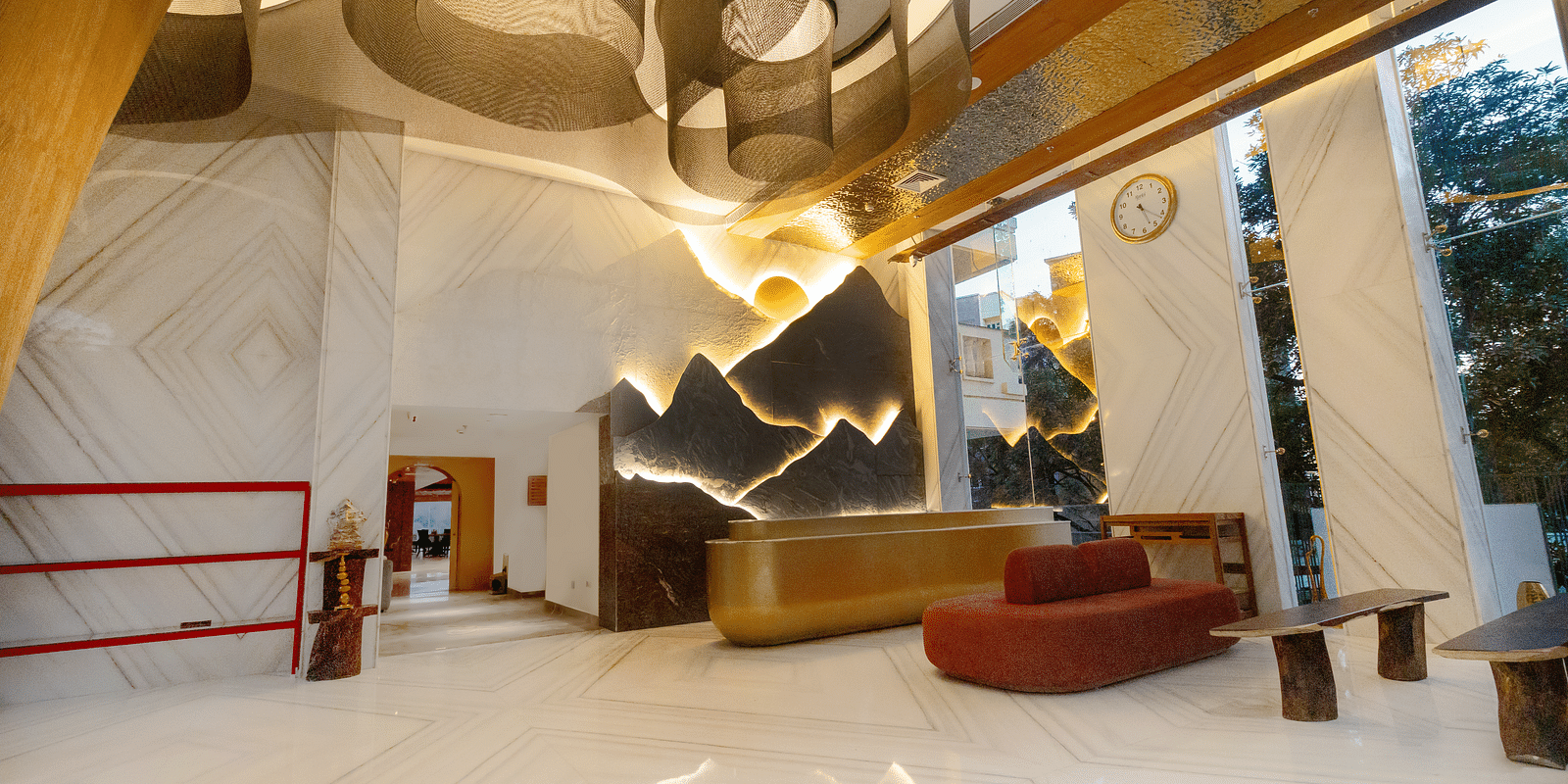 Image of a reception with a seating area and glass walls on the side at Auradoon, Dehradun.