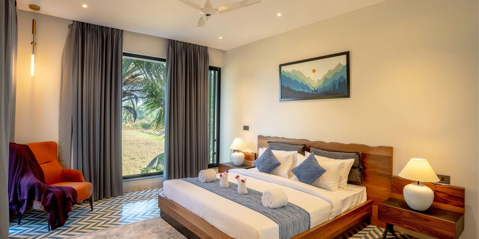 A cosy room featuring a neatly made bed, matching side tables, a large window that fills the space with natural light, and contemporary furnishings