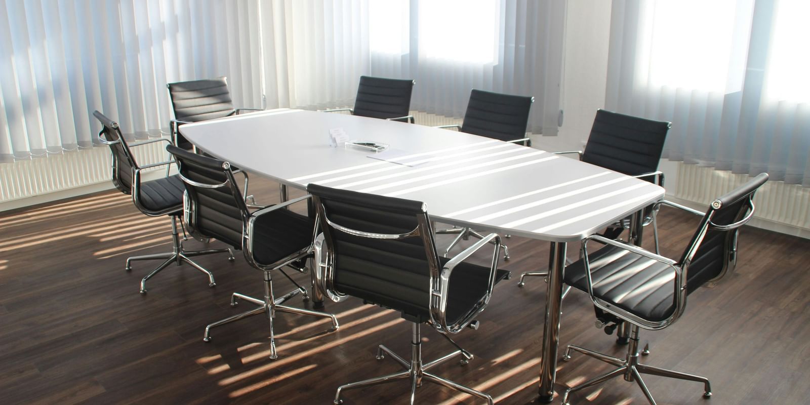 Minimalist modern meeting room featuring a sleek oval conference table and chairs