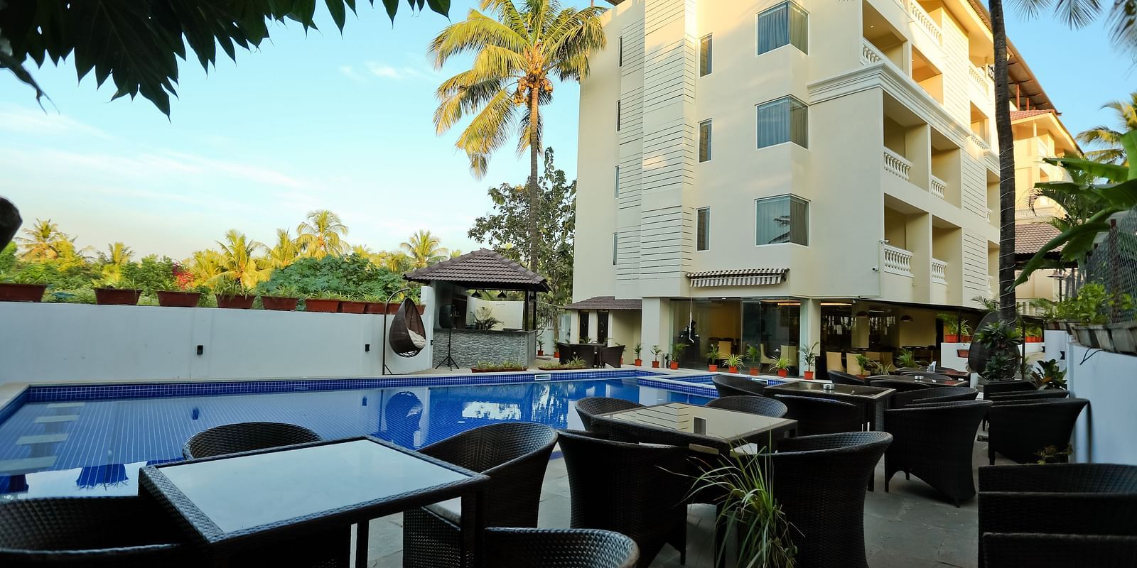 Facade of Calux Grand Baga with chairs and tables in front of it.