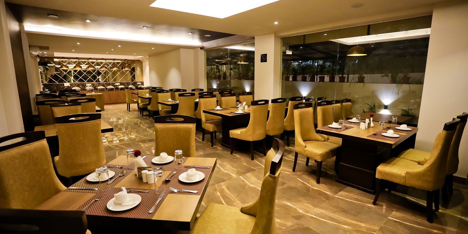 Image of a dining space with crockery placed on the tables and chairs surrounding it at Calux Grand Baga.