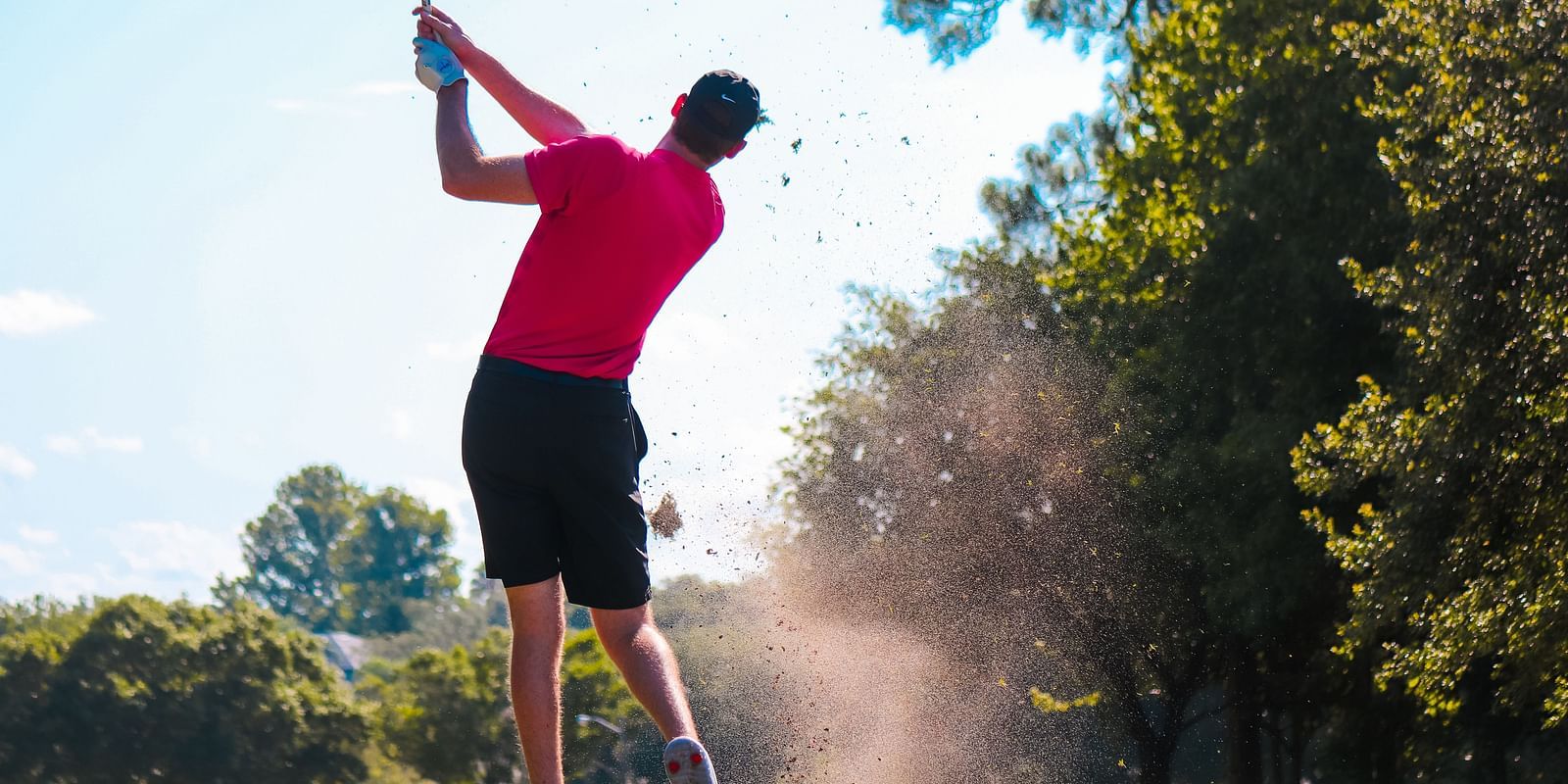 a golfer in full swing after taking the shot 