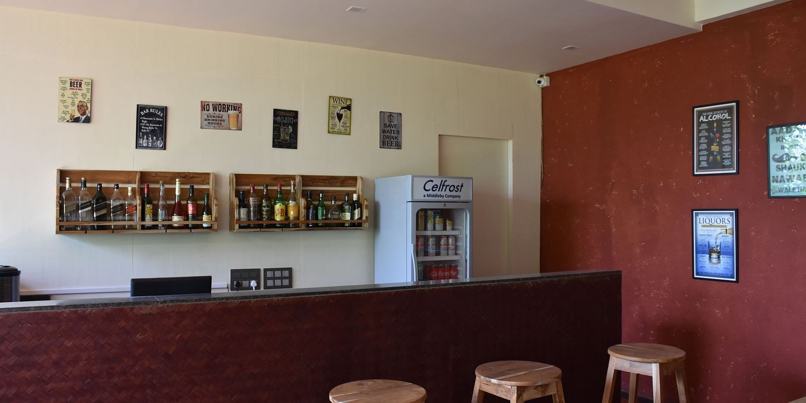 The bar area at Forest Escapes Koyna features stools and a counter, ready to serve guests.