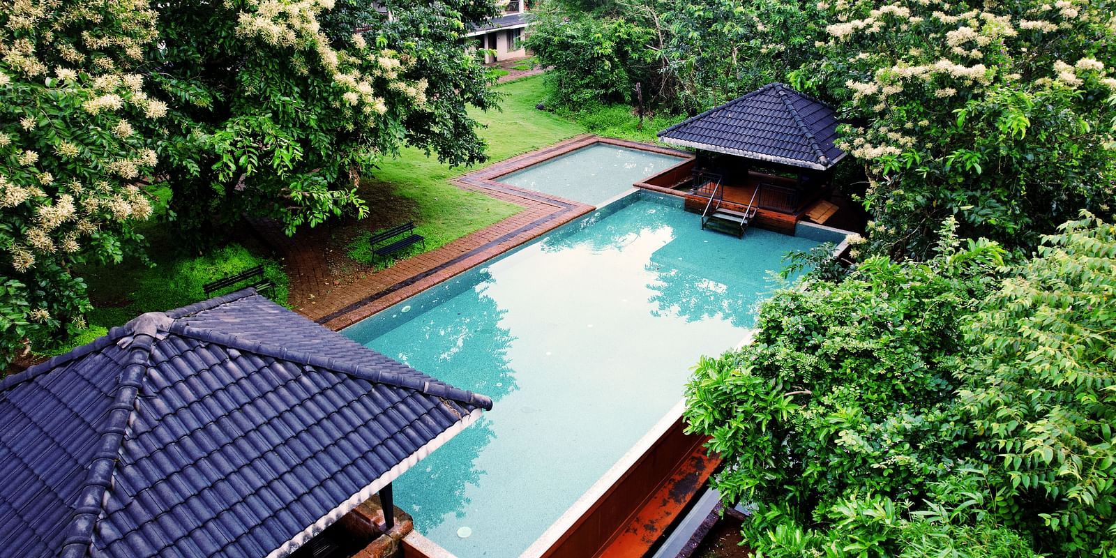 A high-angle view at Forest Escape showcases a large, inviting swimming pool with a covered seating area.