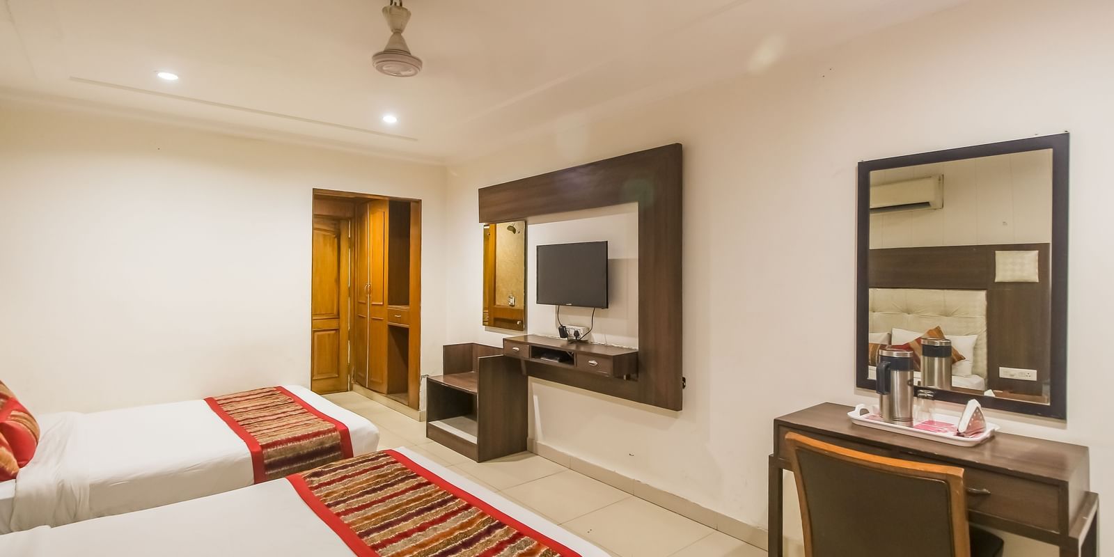 Well-lit Family Room with two queen size beds, wooden accents, and contemporary furnishings - Hotel Diamond Plaza, Chandigarh.