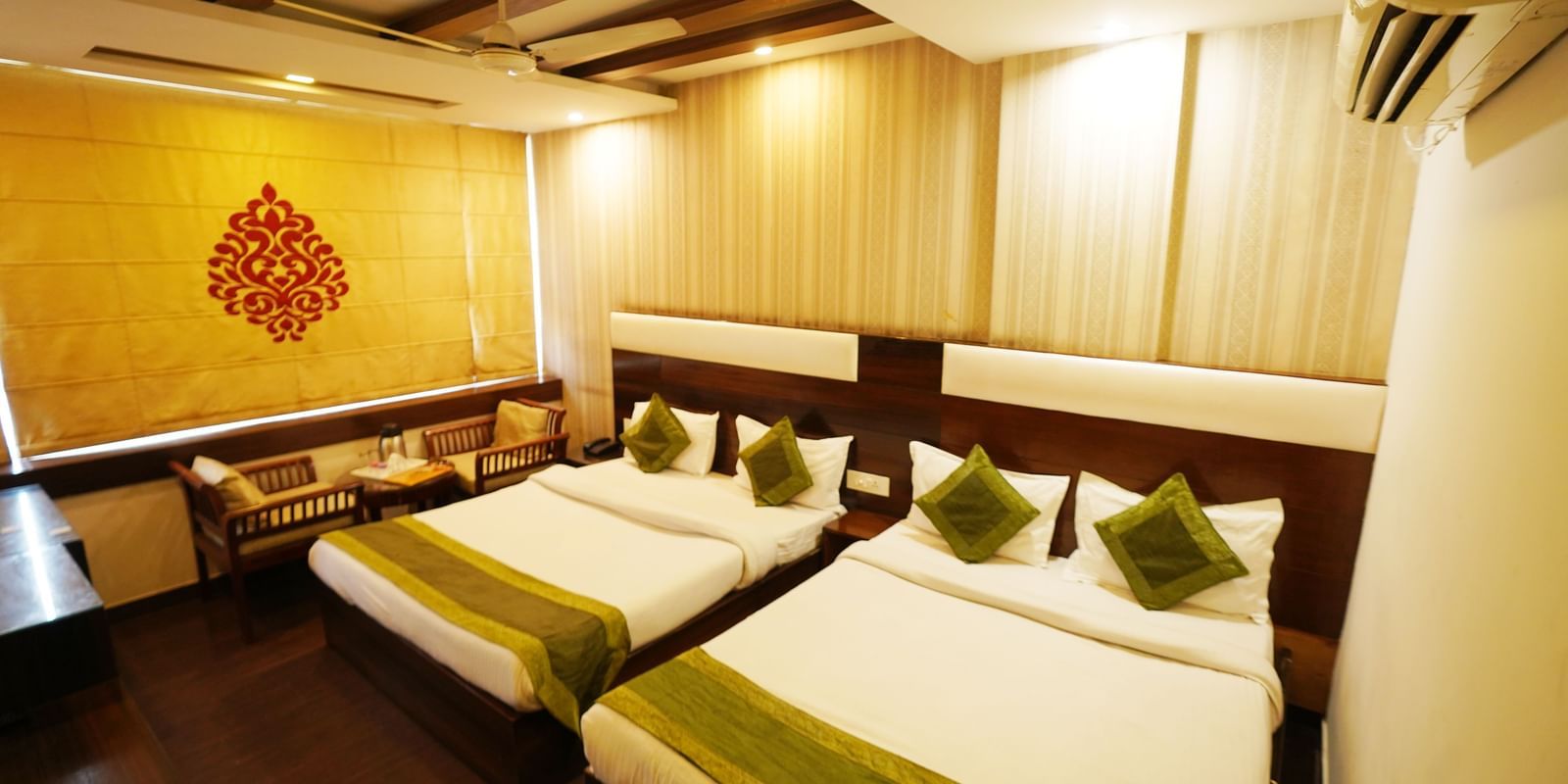 Family Room featuring two beds, a decorative wall design, and an air-conditioning unit.- Hotel Dreamland, Chandigarh